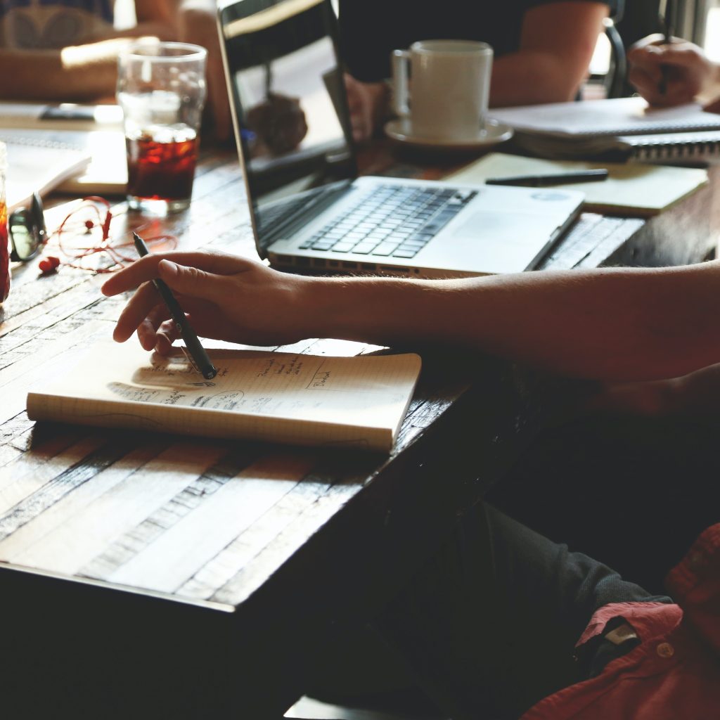 Interns working on a research using laptop and books